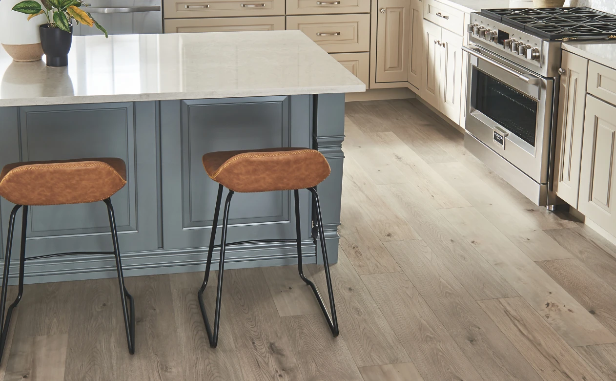 Laminate flooring in a kitchen with an island and two barstools